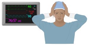 Female CRNA holds her head as a medical alarm rings behind her. The AACN has created a practice alert outling recommendations to mitigate alarm fatigue and false alarms during medical care. 